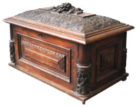 A 19TH CENTURY OAK CELLARETTE, of sarcophagus form, the domed cushion top profusely carved with