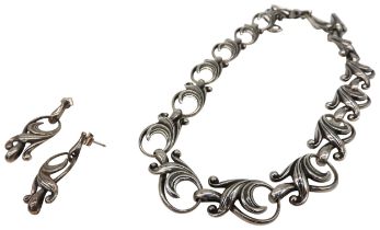 A SILVER NECKLACE AND MATCHING EARRINGS, in an elegant scrolling foliate form Chain 43 cm long