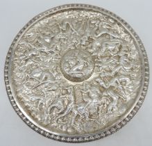 A DECORATIVE CIRCULAR WHITE METAL PANEL, profusely decorated in low relief with a highly detailed