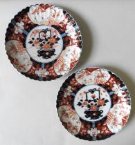 A PAIR OF JAPANESE IMARI DISHES, scallop form with painted flower basket decoration 31 cm diam