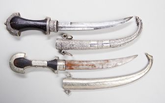 A JAMBIYA, PROBABLY MOROCCAN, the wooden hilt with white metal decoration and ornate white metal