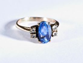 A SAPPHIRE RING the oval mixed-cut sapphire, claw set between pairs of white stones. Ring size G