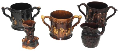 THREE MID 19TH CENTURY TREACLE GLAZE POTTERY LOVING CUPS, the sides moulded in low relief with
