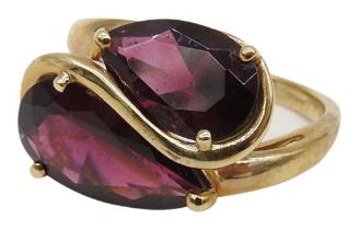 A 9CT GOLD CROSS OVER RING, set with two graduated teardrop cut gem stones Weight: 4 grams