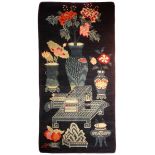 A good Chinese antique rug blue ground depicting a large vase flowers upon an urn stand. Possibly