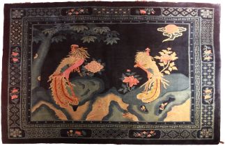 A good Chinese blue ground rug depicting 2 exotic birds amongst foliage, late 19th century. Possibly