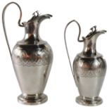 Two Viennese silver ewers with scrolled handles & acorn leaf etched design upon circular bases. - (