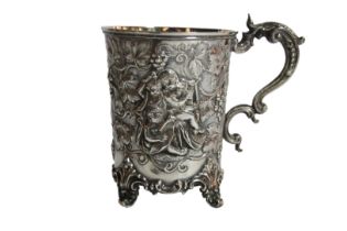 A superb silver beaker/ cup with cherub vine scrolled decoration upon four Roco scrolled feet,