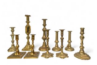 A PAIR OF GEORGIAN PETAL BASE BRASS CANDLESTICKS, along with a single George III brass hexagonal