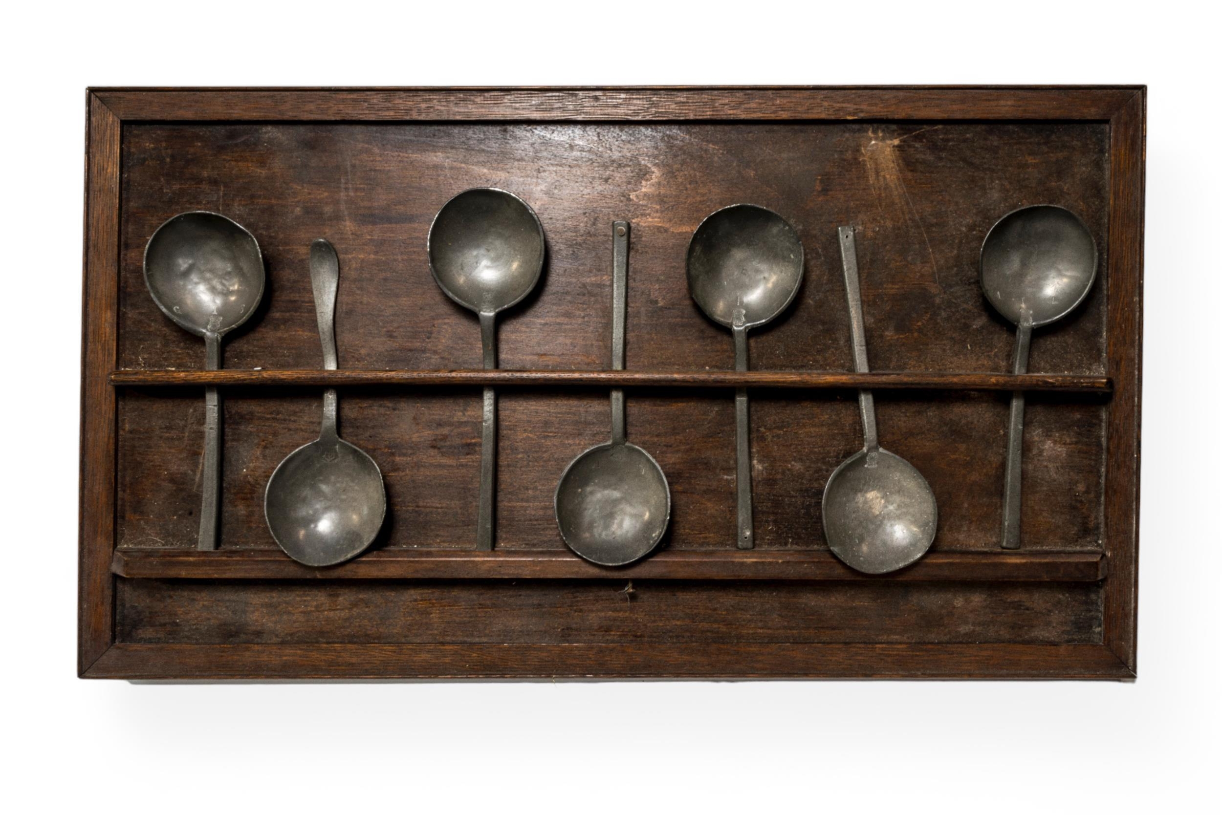 A GROUP OF SEVEN PEWTER SPOONS some with crowned rose touch marks and initials and mounted on a