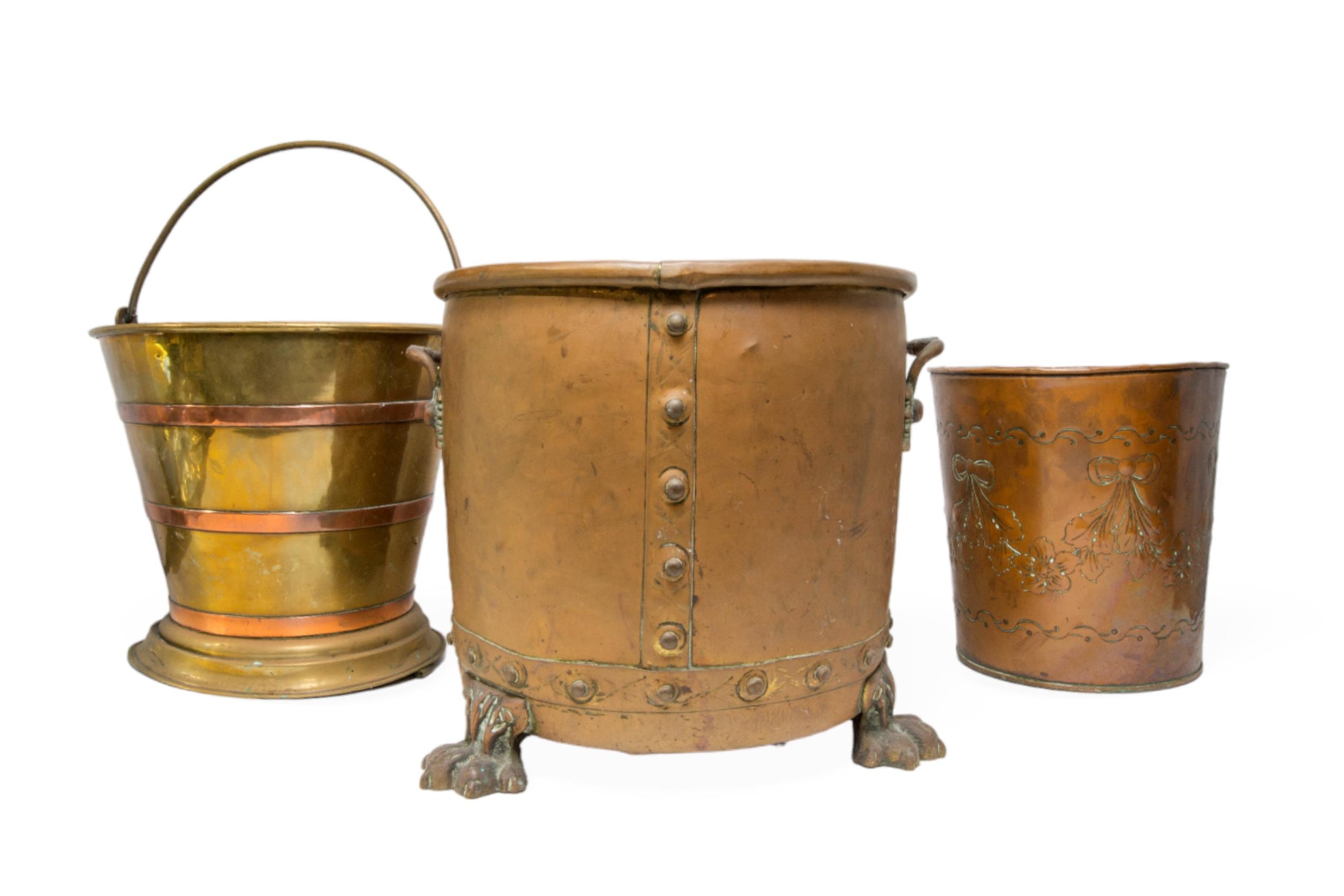 A COPPER AND BRASS COAL BIN with riveted detail and lions paw feet, a copper and brass banded coal