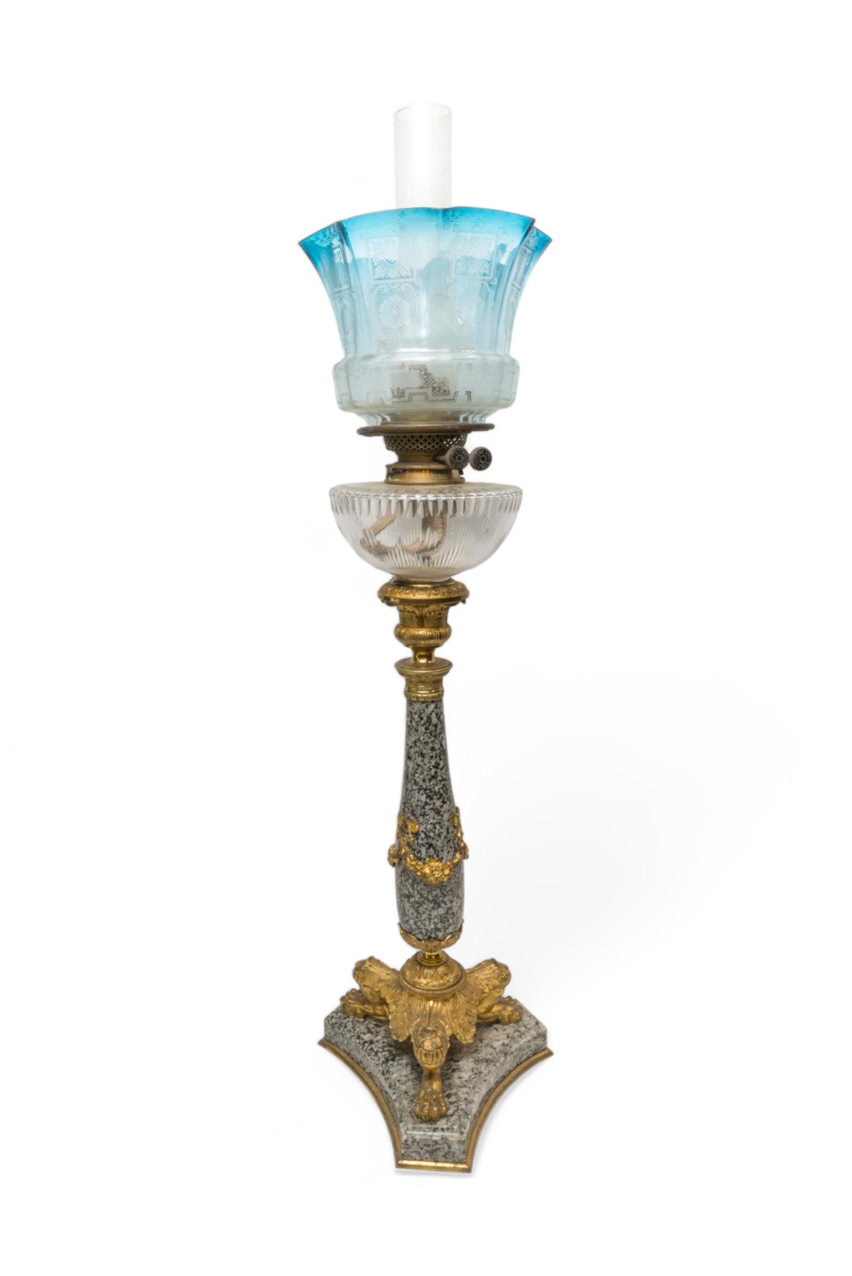 A GOOD 19TH CENTURY POLISHED STONE OIL LAMP with gilt tri-form platform base and mounts with cut