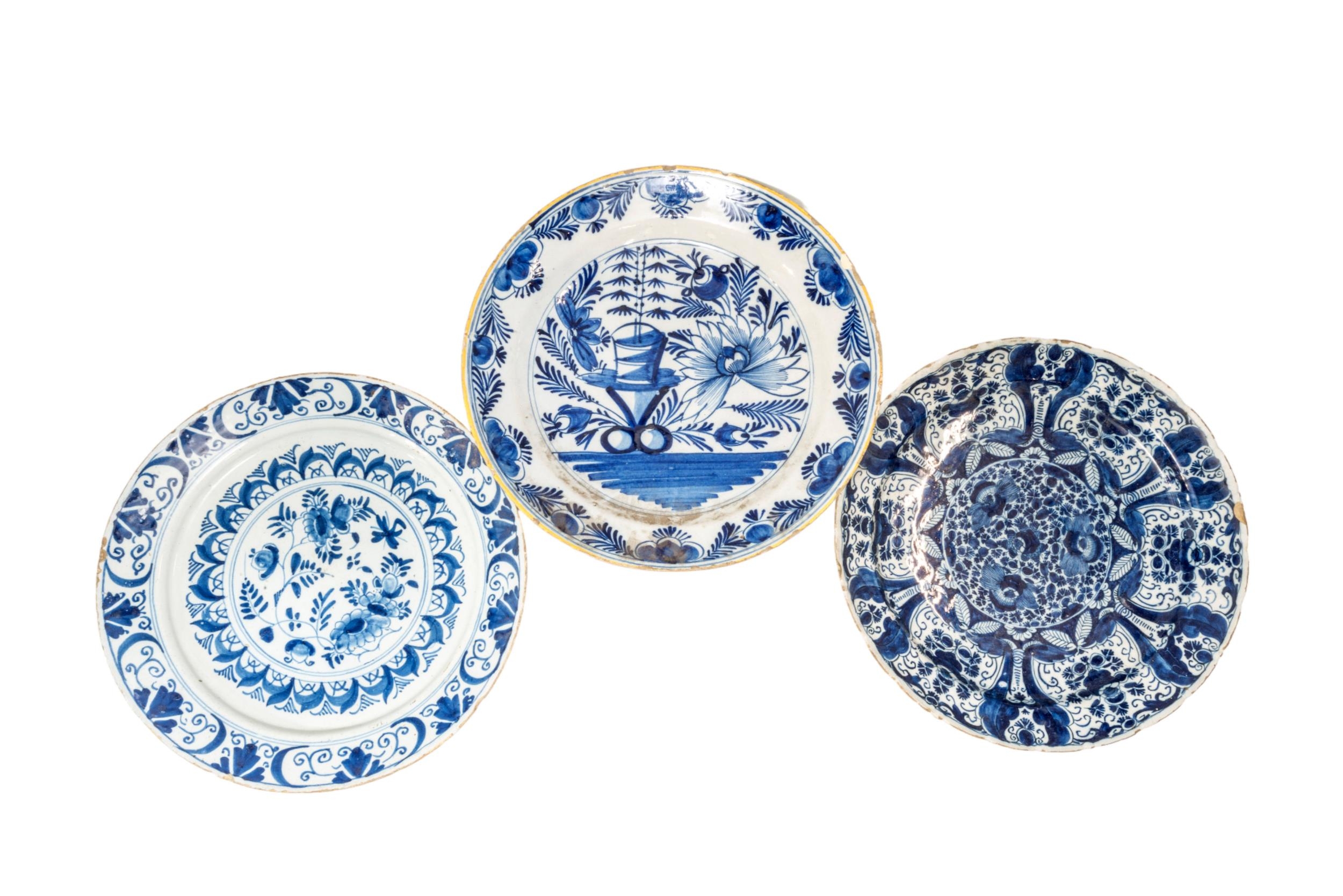 A GROUP OF THREE DUTCH DELFT DISHES, 18TH CENTURY, the lot includes one painted with a profusion