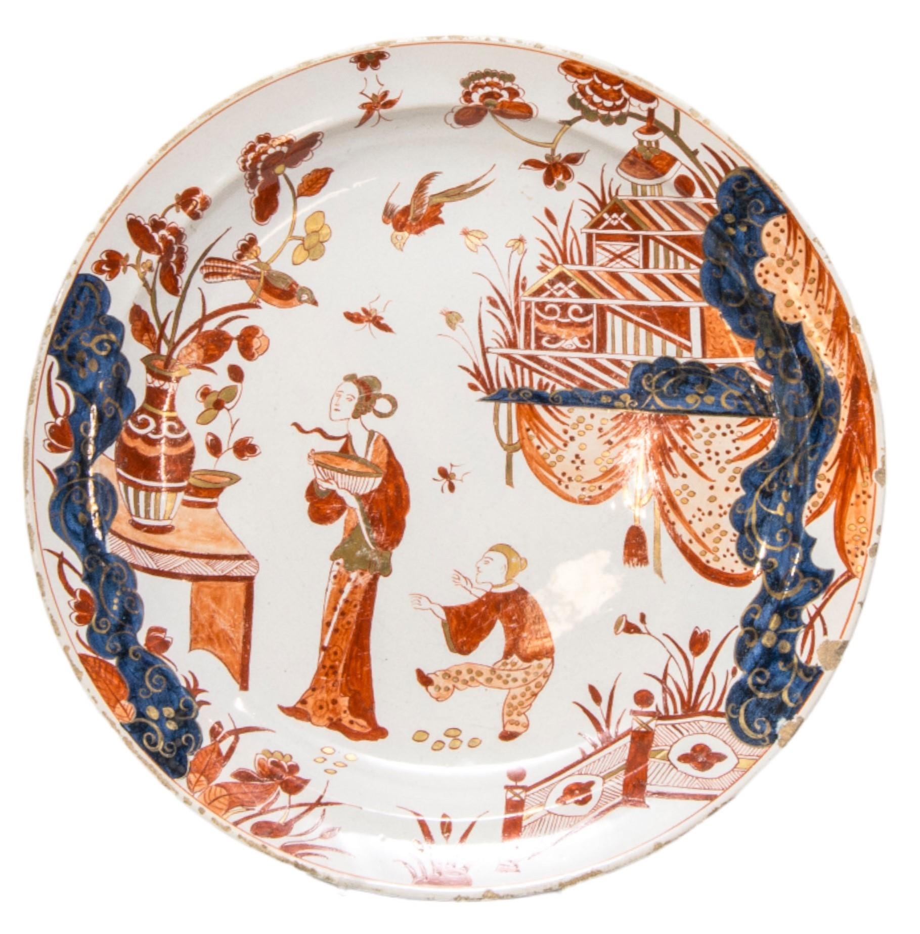 A DUTCH DELFT DISH, 18TH CENTURY, painted in the Imari palette with gilded detailing, depicting