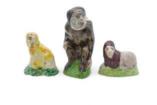 THREE EARLY STAFFORDSHIRE ANIMAL FIGURES Early 19th century, a seated monkey, recumbent lion and a