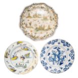 AN 18TH CENTURY DELFT DISH, the centre painted with fruits enclosed by scrolling reserves, along