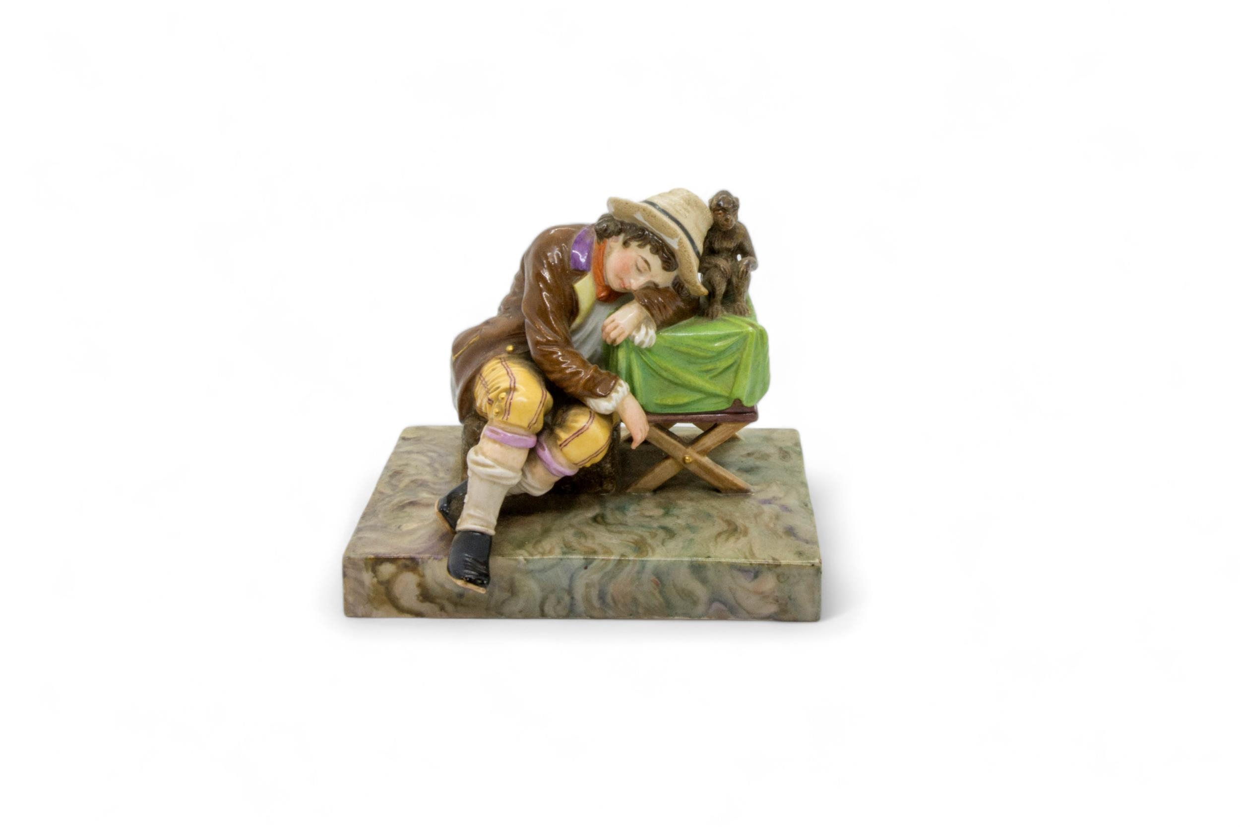 A 19TH CENTURY FIGURAL GROUP A boy sleeping next to a performing monkey, 13cms wide