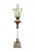 A VICTORIAN OIL LAMP with milk glass column upon a brass base with red glass reservoir and etched