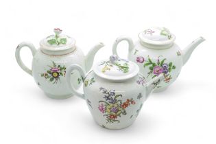 THREE ENGLISH 18TH CENTURY TEAPOTS Decorated with floral sprigs, 12cms high.
