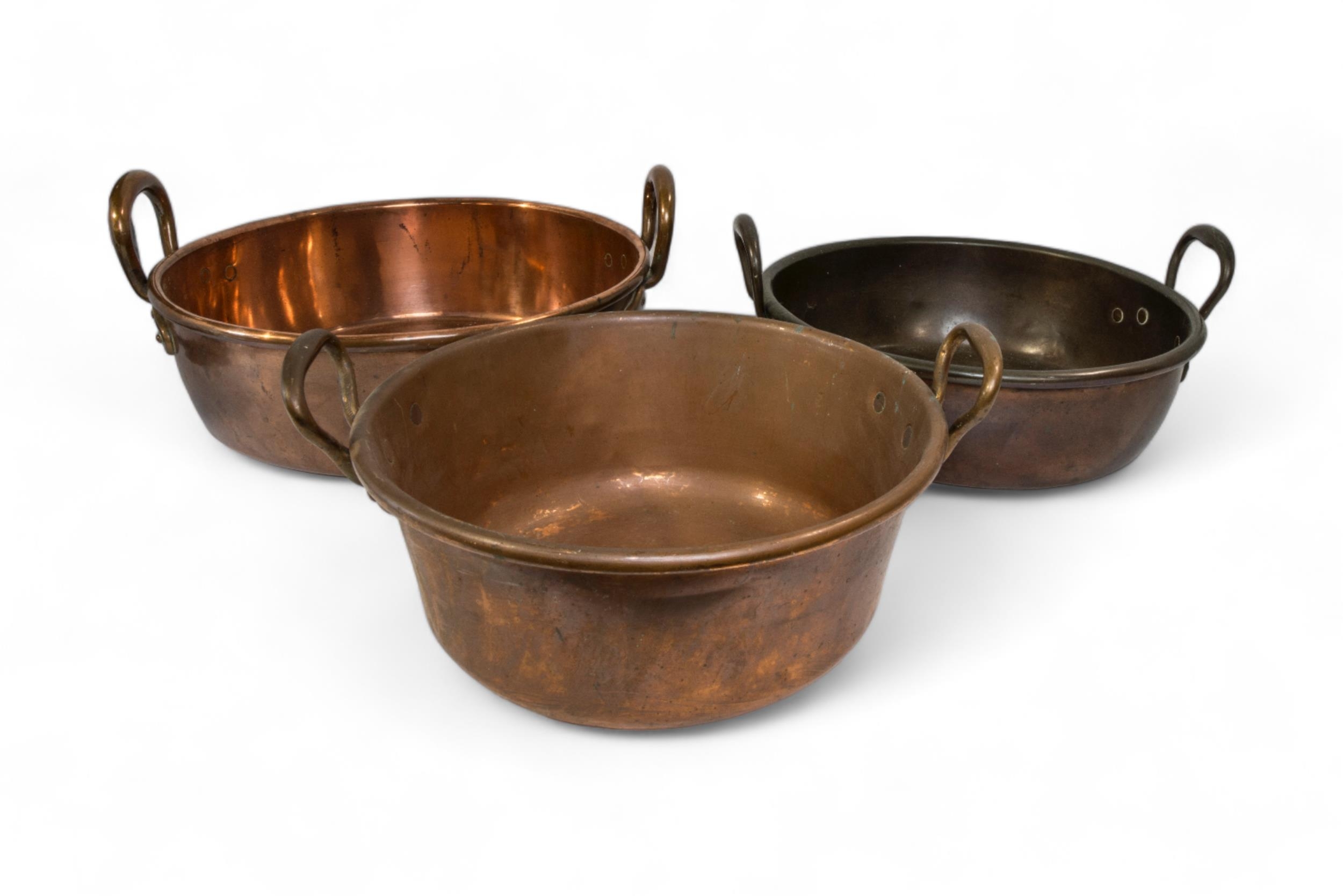 A COPPER TWIN-HANDLED PAN AND TWO OTHERS. 38 cms diam