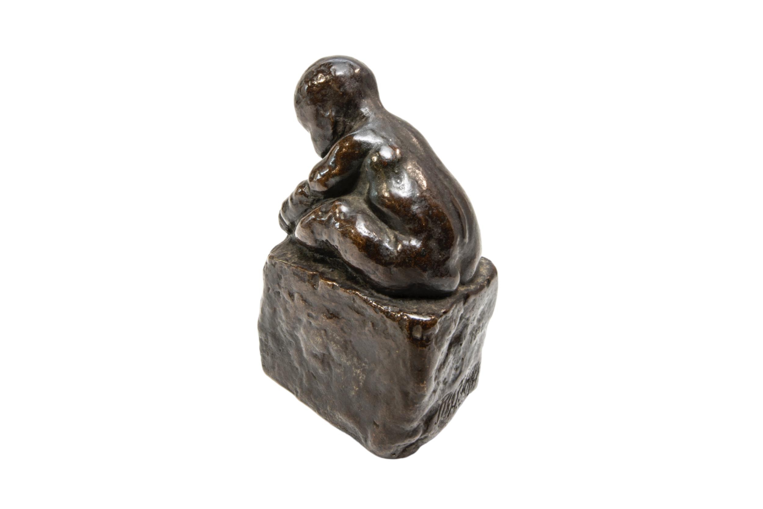 A CAST BRONZE FIGURE OF A CROUCHING INFANT, modelled holding his foot, sat atop a rectangular - Image 2 of 3
