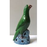 A CHINESE SANCAI GLAZED PARROT, LATE 19TH / EARLY 20TH CENTURY, modelled perched atop a rocky
