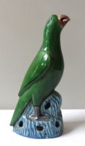 A CHINESE SANCAI GLAZED PARROT, LATE 19TH / EARLY 20TH CENTURY, modelled perched atop a rocky