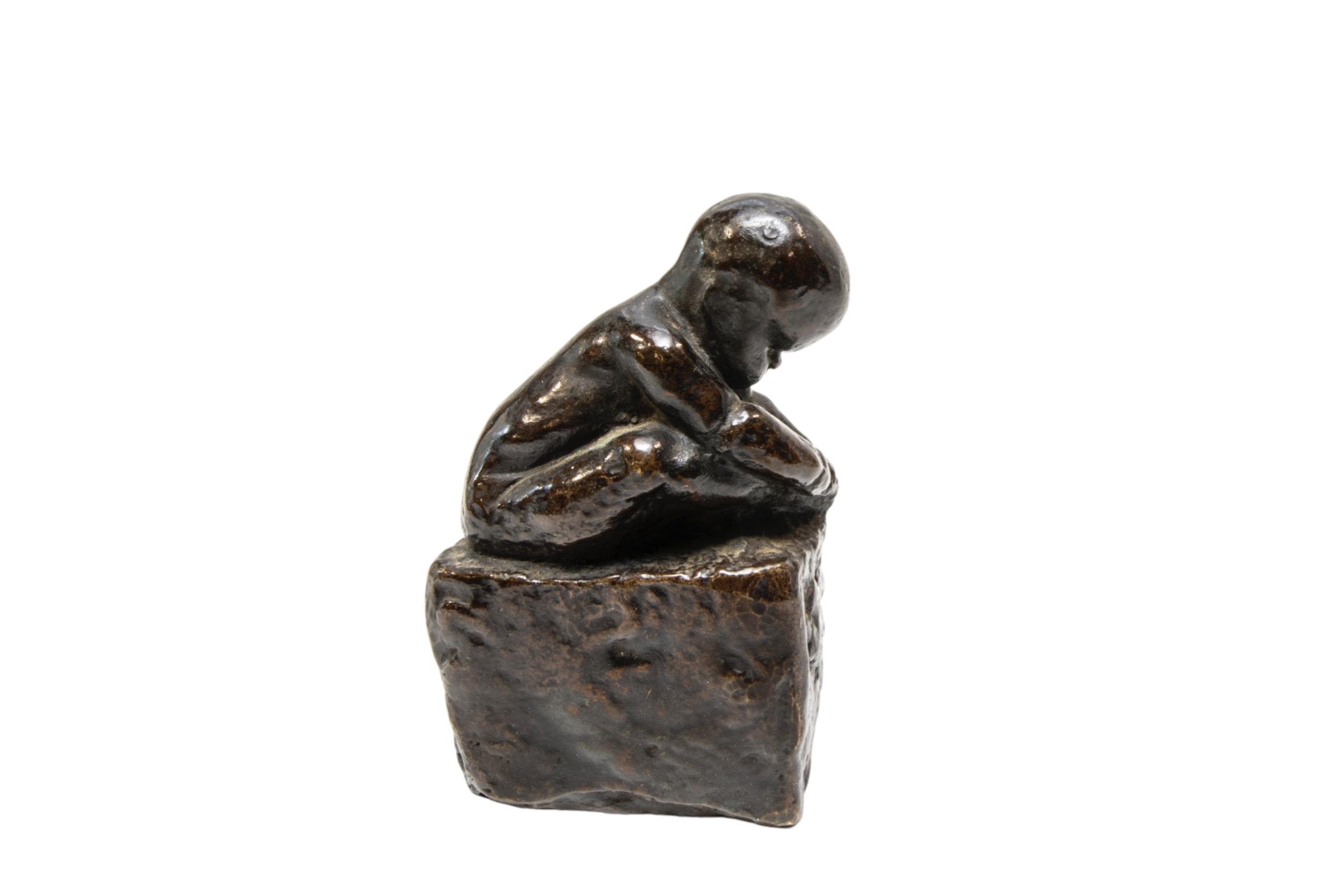 A CAST BRONZE FIGURE OF A CROUCHING INFANT, modelled holding his foot, sat atop a rectangular - Image 3 of 3