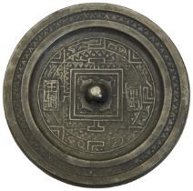 A CAST BRONZE MIRROR HAN DYNASTY (202BC - 220AD) a pierced knob centered within a square border,