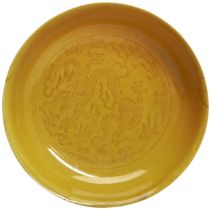 AN INCISED YELLOW-GLAZED 'DRAGON' DISH QIANLONG SEAL MARK AND OF THE PERIOD 清乾隆 黄釉暗刻龙纹盘 finely