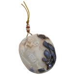 A CARVED AGATE PENDANT  19TH/20TH CENTURY  carved with two scholars walking in landscape, with