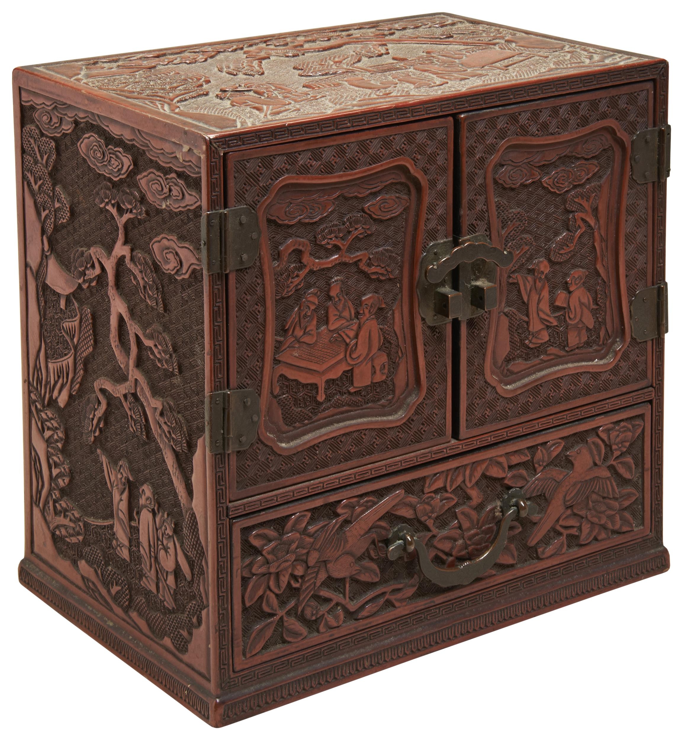 A CINNABAR LACQUER TABLE CABINET QING DYNASTY, 19TH CENTURY the exterior carved with lotus blossoms,
