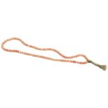 A CHINESE CARVED CORAL BEAD NECKLACE QING DYNASTY, 19TH CENTURY with a plaited silk tassel  38cm