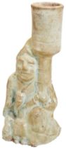 A GREEN GLAZED POTTERY MODEL OF A KNEELING MIDDLE EASTERN FIGURE WITH LEFT KNEE RAISED, EASTERN