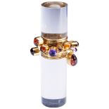 WENDY RAMSHAW; AN AMETHYST, GARNET, AND GOLD RING ON AN ACRYLIC STAND the ring composed of twelve