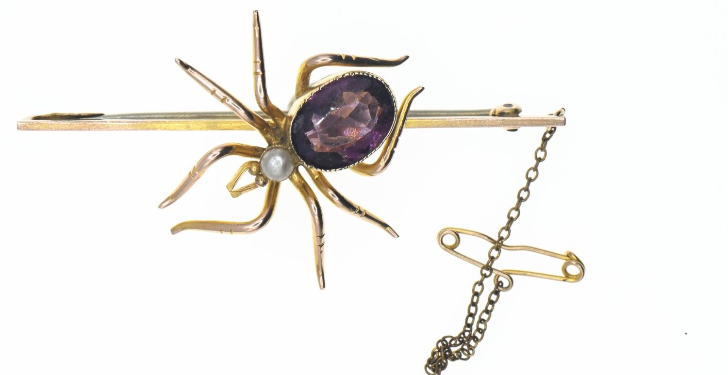 9ct gold mounted spider bar brooch. Body set with a purple paste stone and seed pearl. Gross weight 