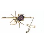 9ct gold mounted spider bar brooch. Body set with a purple paste stone and seed pearl. Gross weight 