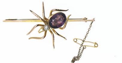 9ct gold mounted spider bar brooch. Body set with a purple paste stone and seed pearl. Gross weight