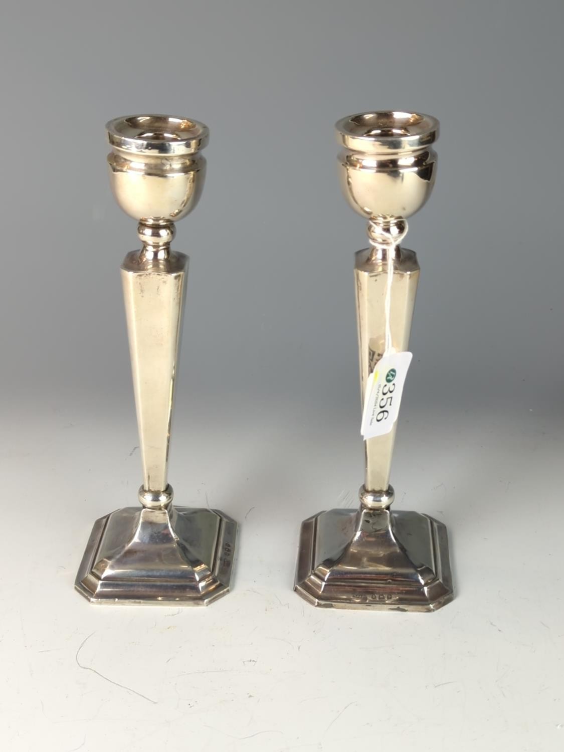 Pair of silver candlesticks, Britton, Gould & Co, Birmingham 1939, each with urn-shaped nozzles, tap