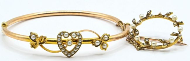 Yellow metal and seed pearl set bangle with a heart and leaf design testing positive for 14ct gold.