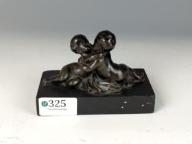 Small patinated bronze figural group of two kissing putti, on a rectangular black slate base, unmark