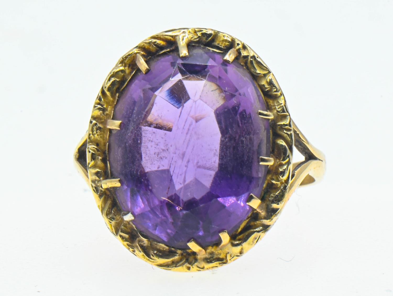 Amethyst set yellow metal ring. Oval mixed cut amethyst approximately 19mm x 14mm. Size T 1/2. Gross