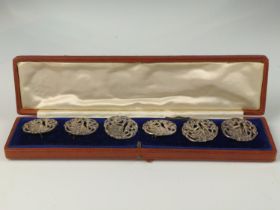 Cased set of six George V silver buttons, William Comyns & Sons, London 1913, of pierced figural des