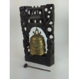 Eastern temple bell on carved wooden stand. 25cm x 38cm high. 