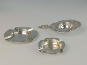 Continental 800 grade silver tea strainer, 56 grams, and two silver small ashtrays, the largest hall