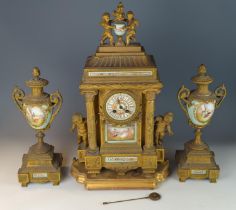 Ornate gilt metal mantle clock with garniture. Featuring painted porcelain panels and face with cher