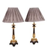 A PAIR OF GILT AND PATINATED METAL TRIFORM CANDLESTICKS