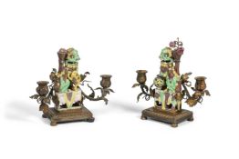 A PAIR OF CHINESE SANCAI GLAZED BUDDHIST LION GILT-METAL MOUNTED TWO-BRANCH CANDELABRA THE PORCELA