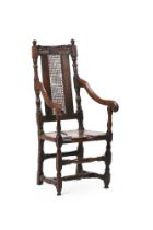 A CHARLES II CARVED OAK HIGH BACK OPEN ARMCHAIR