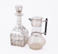 A GLASS DECANTER WITH SILVER COLOURED OVERLAY